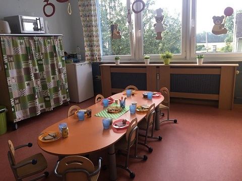 Der Essensraum mit gedeckten Tischen und kleinen Stühlen