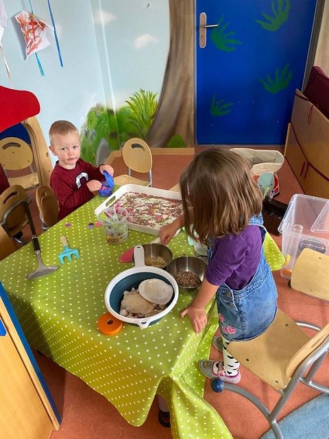 Kinder sitzen am Tisch und essen zu Mittag