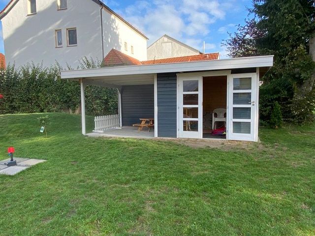 Hölzernes Gartenhaus am Rand der Wiese