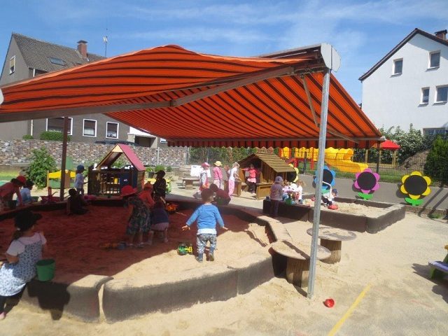Sandkasten unter einem Sonnensegel im Garten