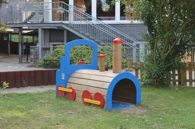 Blaue Holz-Lokomotive zum Spielen auf dem Außengelände
