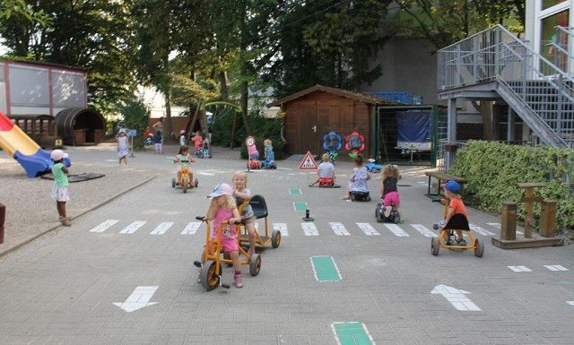 Kinder üben bei der Verkehrserziehung das Überqueren der Straße